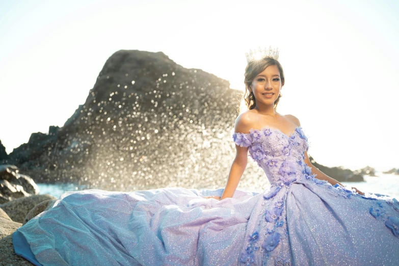 a beautiful young woman in a dress standing next to water