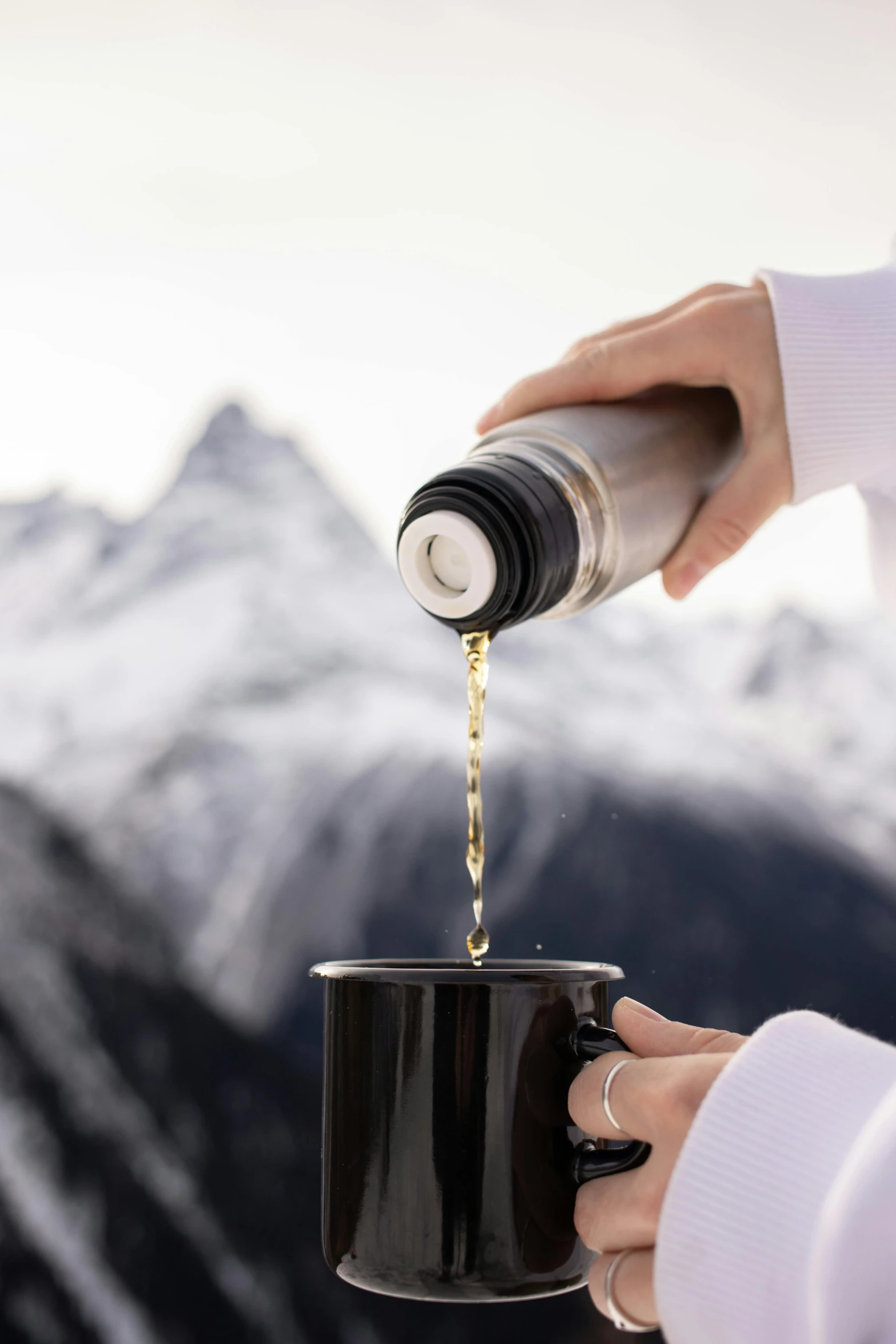 the person is pouring coffee from a small coffee pot