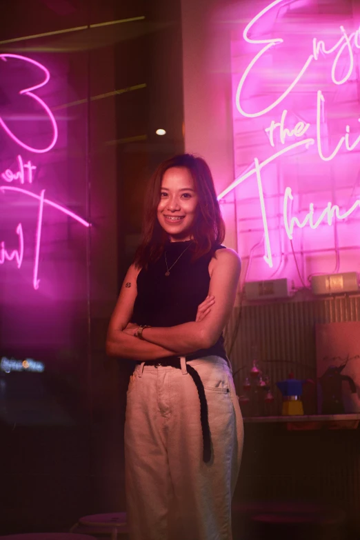 a woman stands in front of the neon signs