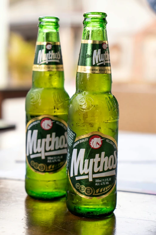 two green bottles filled with drinks sitting on a table