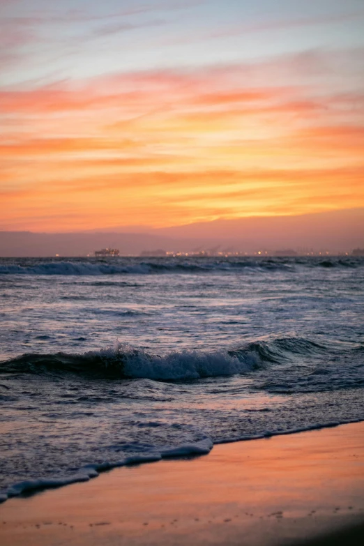 the ocean with a sunset and some boats