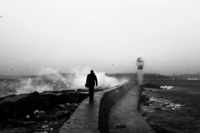 a person walking down a pathway along the ocean