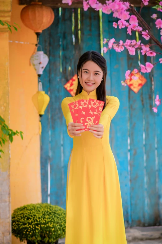 a girl in yellow dress standing next to blue background