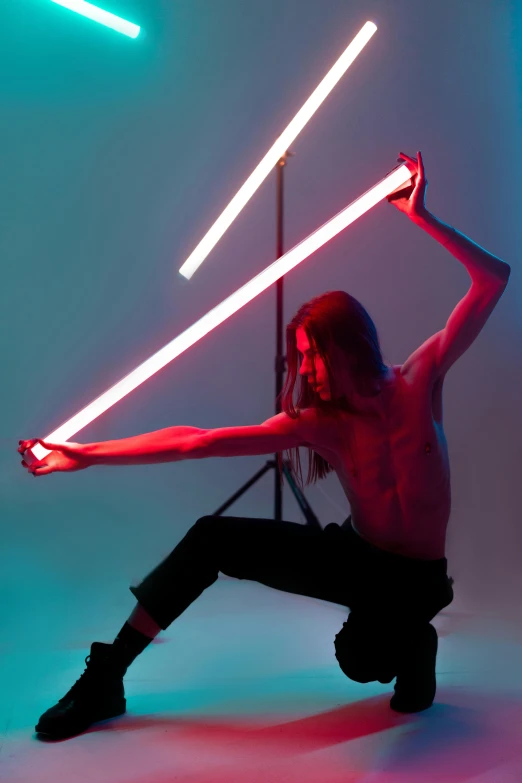 a girl holding two light swords and standing next to a tripod with her arms out