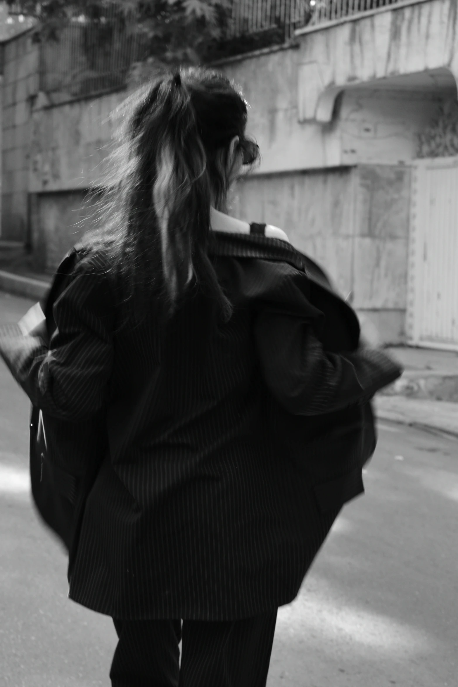 woman with long hair walking down the street