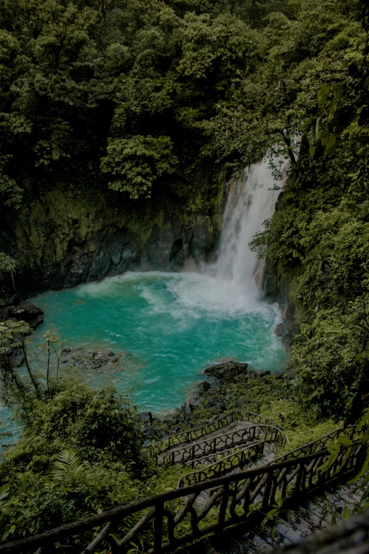 a beautiful blue stream that runs over the top of a waterfall