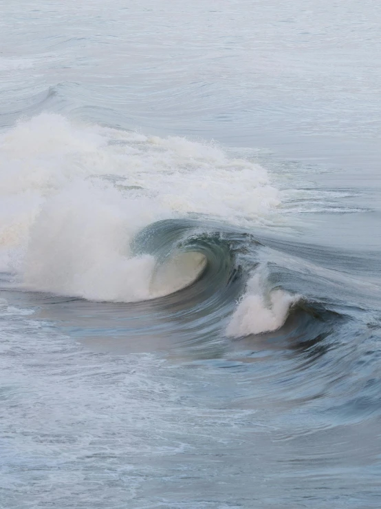 two surfers in the ocean, riding a large wave