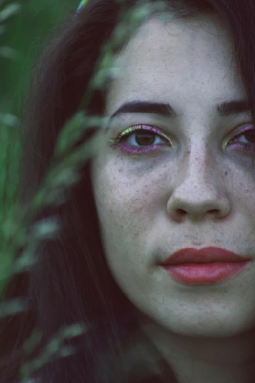 woman with bright colored eye makeup looking in the distance