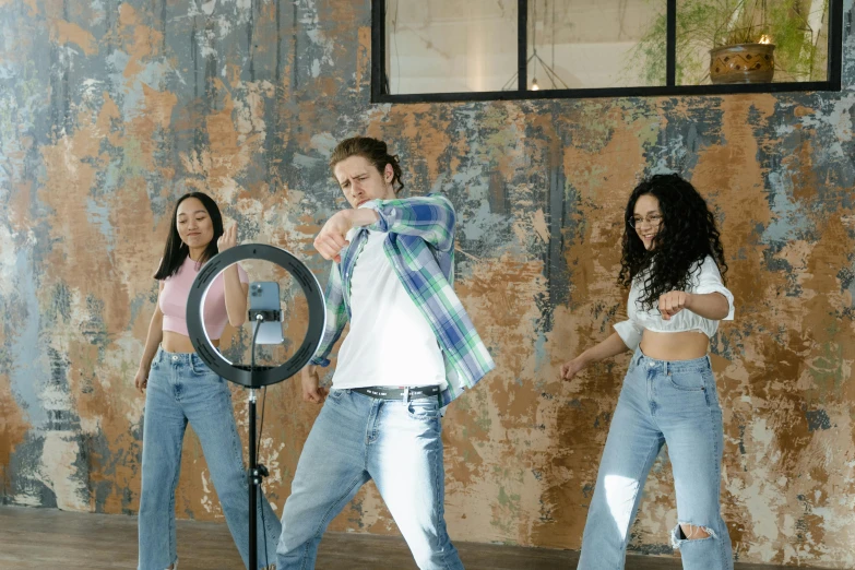 a man on the camera in a studio with some women dancing