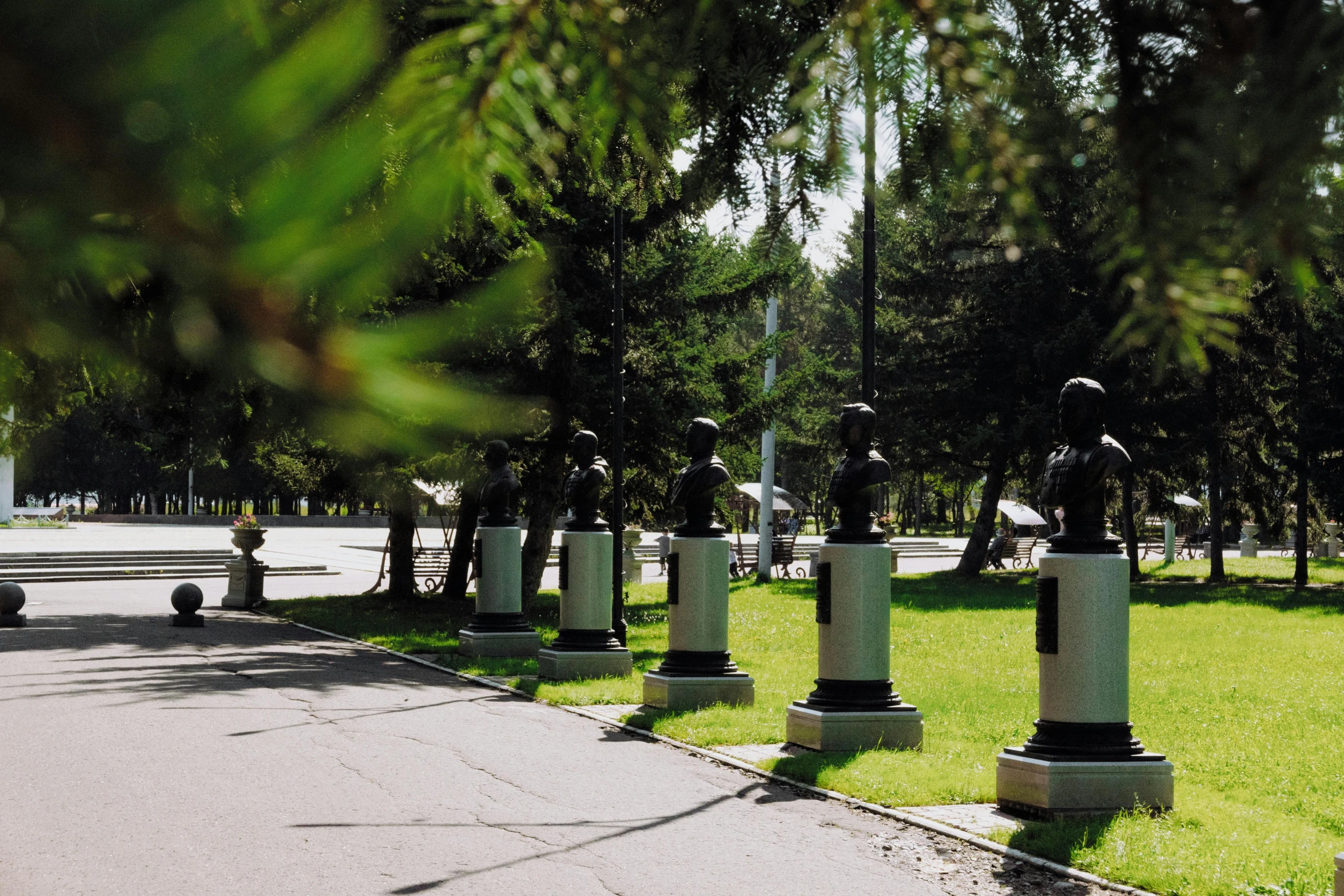 some statues line a park in a city