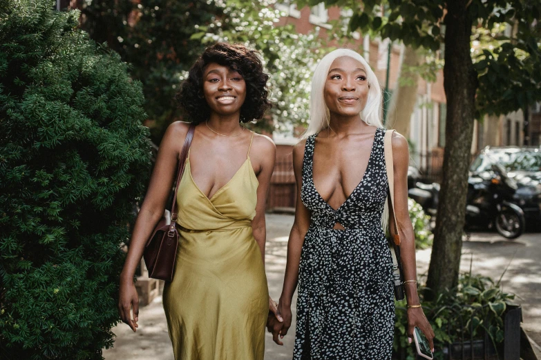 two young women pose in a street for a picture