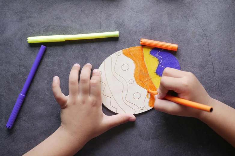 a child is doing arts and crafts with colored crayons