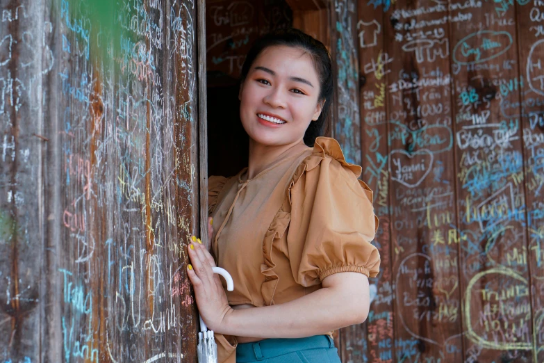 a woman with an orange top standing on a doorway