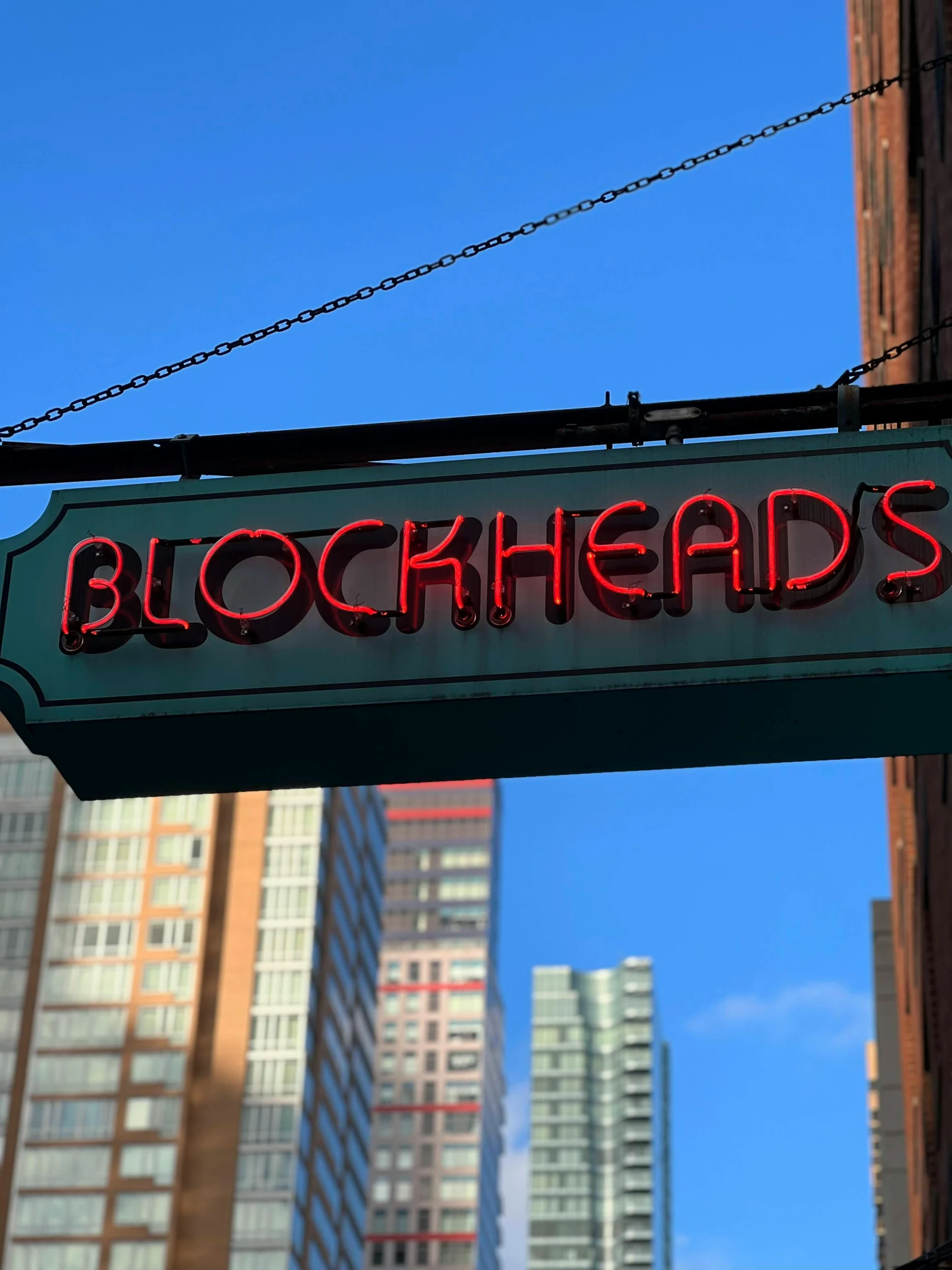 a neon sign above a store front on a street