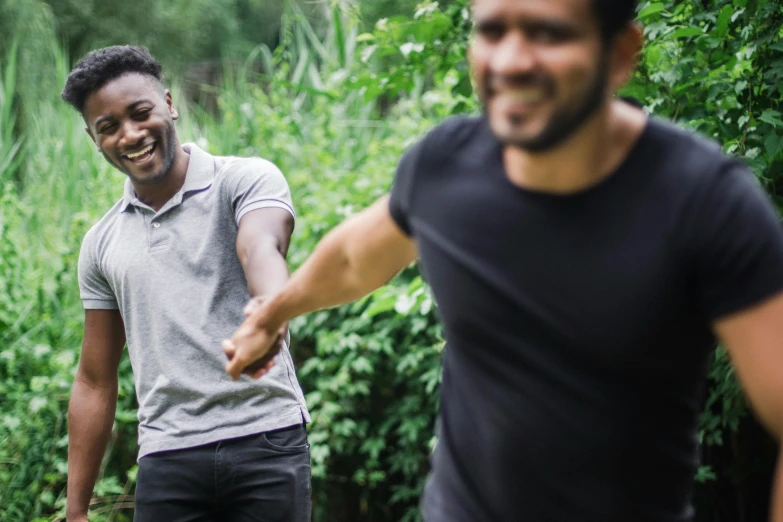 two men playing with a frisbee in the woods