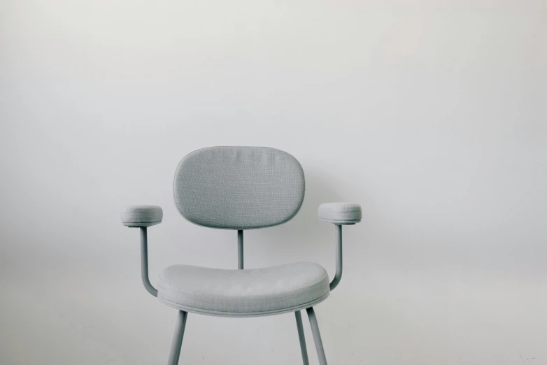 an artistically designed, comfortable chair against a white wall