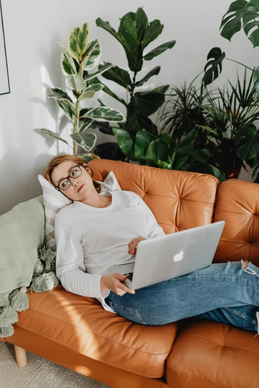 a woman sitting on a couch using her laptop