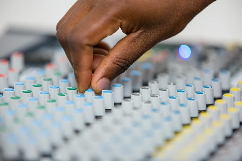 hand pressing ons on sound board in public place