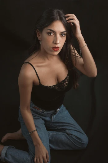 woman in black top and blue jeans posing for pograph