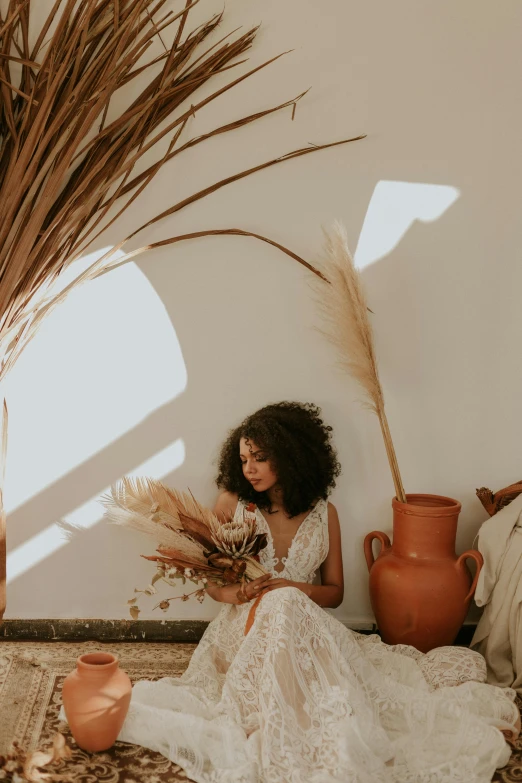 woman sitting with her feet propped up and a bunch of dried grasses beside her