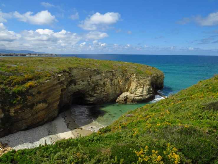 two people on the beach near an open cave