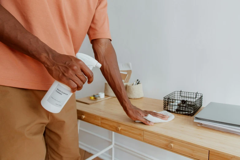 a person cleaning on a table with soing