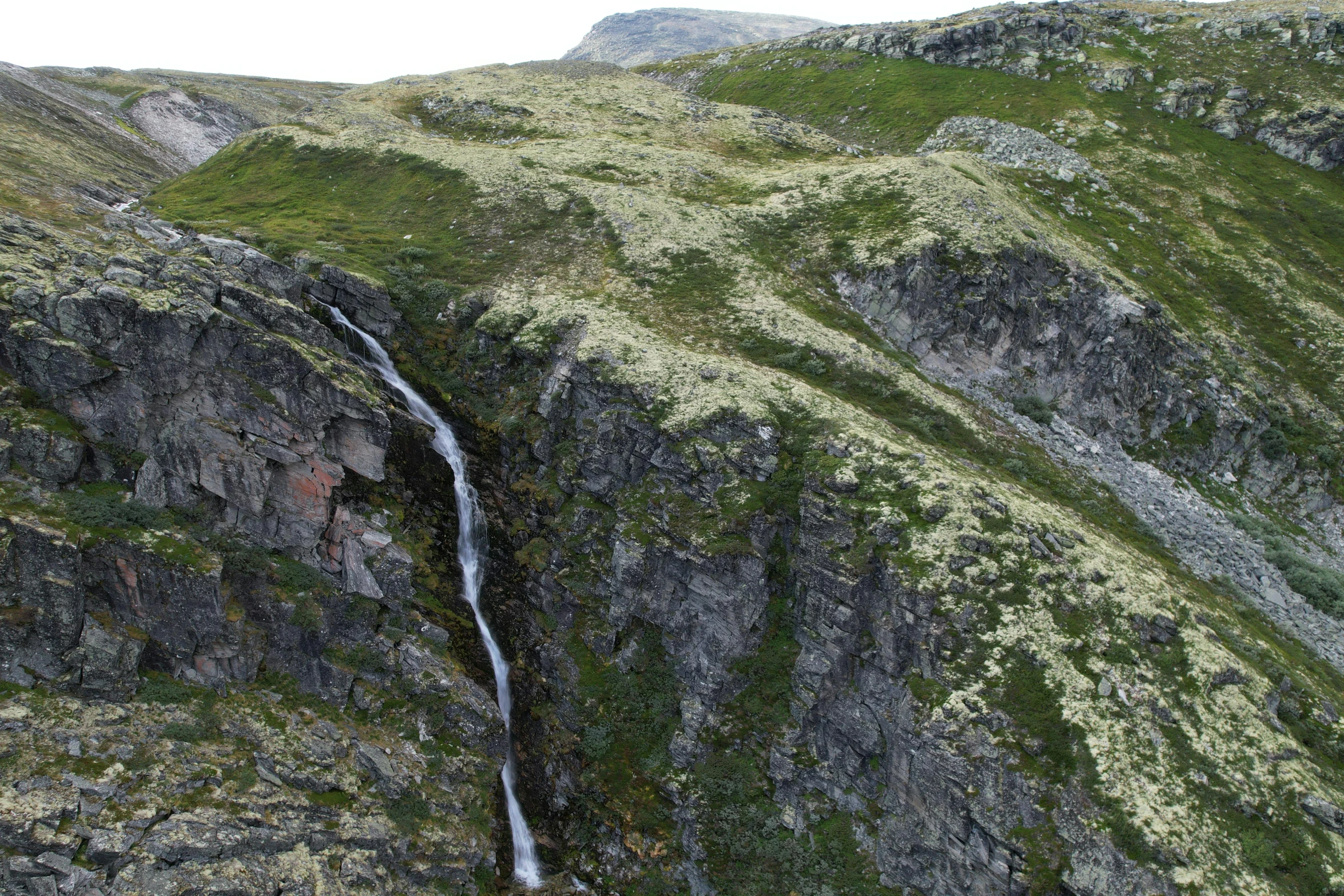 a water fall is shown running down the side of a mountain