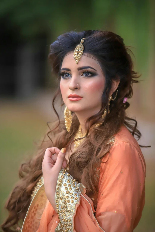 an indian woman wearing jewellery and an orange gown