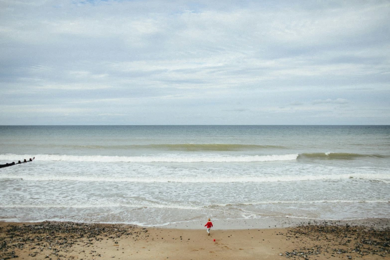 the sky is overcast but there are waves in the beach