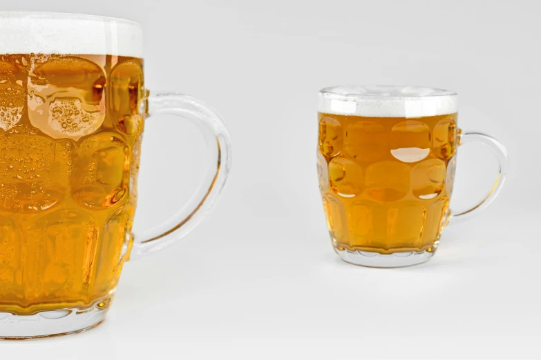 two glasses with very light beers next to each other