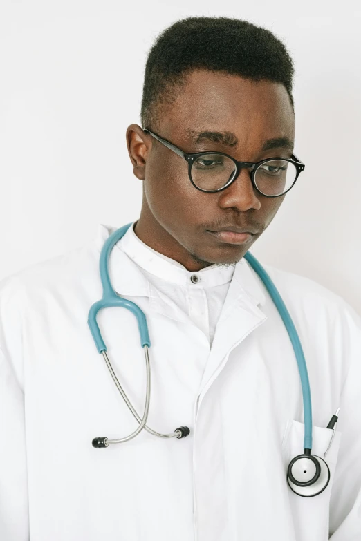 a man in a medical coat and glasses is looking to the side