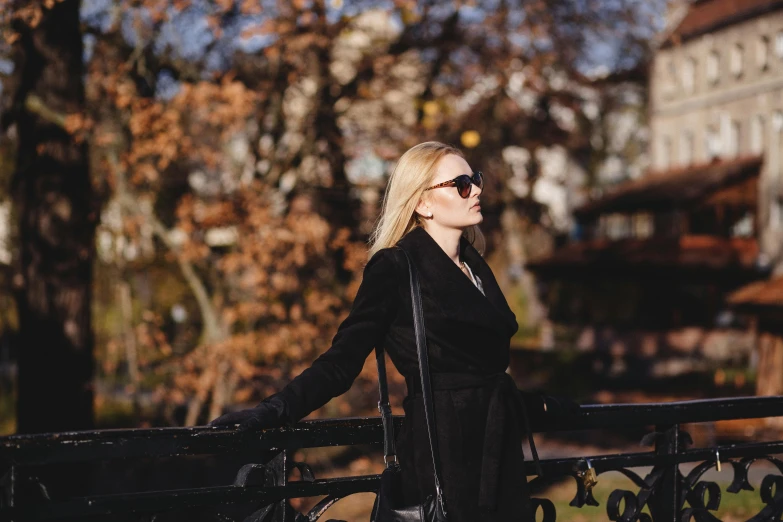 woman standing by a rail next to a tree