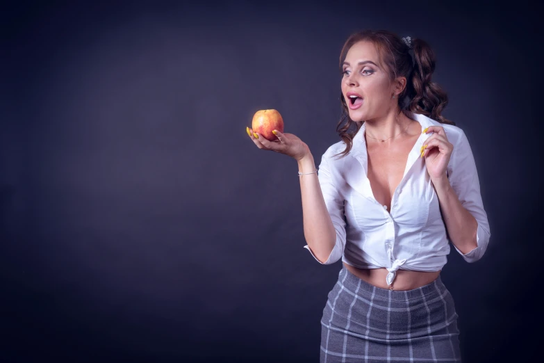 a woman holding an apple and pointing to soing
