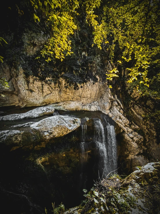 a small waterfall with water spilling from the side