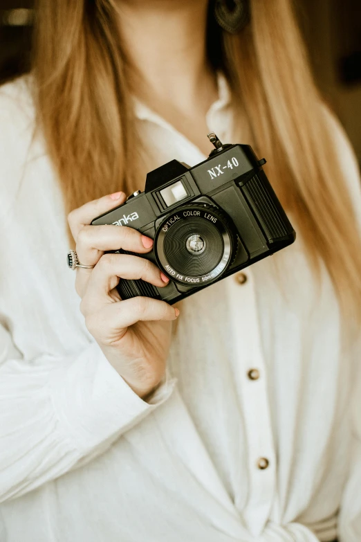 a woman holds up a camera for her self