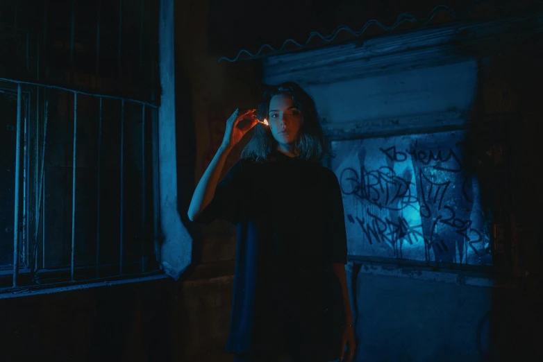 a woman with long hair in the dark holding a lighter