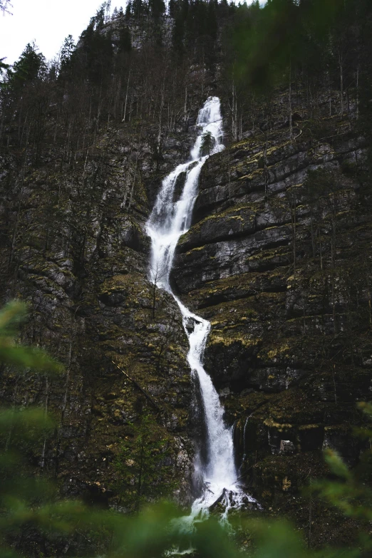 a waterfall is shown against the side of a rock