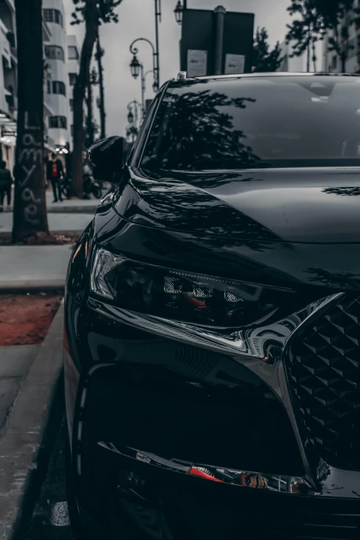 the front of a black car parked in a city street