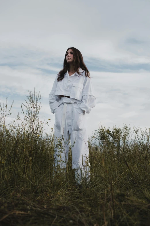 woman wearing white standing on grass in field