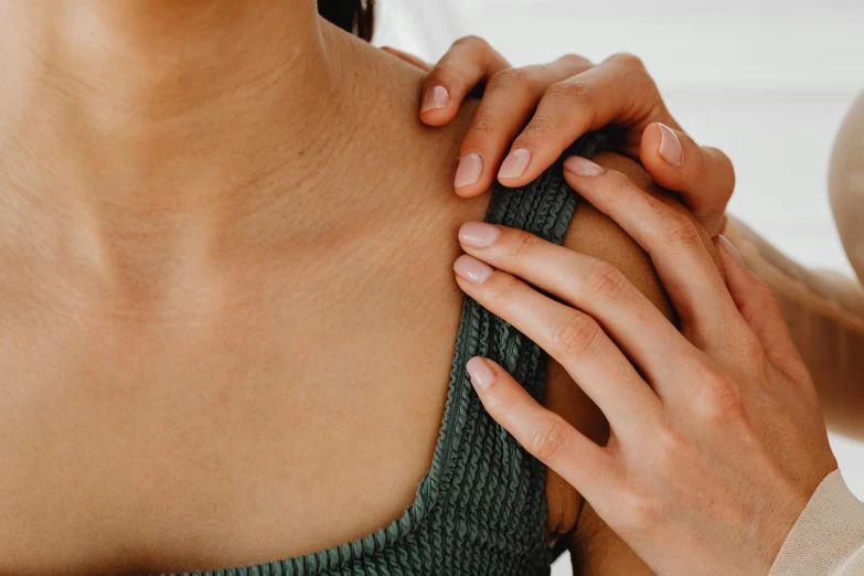 closeup of hands rubbing woman's arm outside