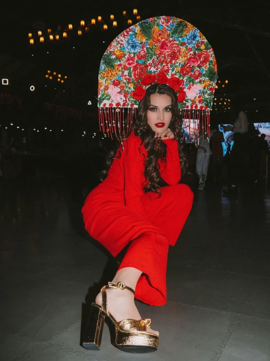 a woman sitting on a chair in a red dress