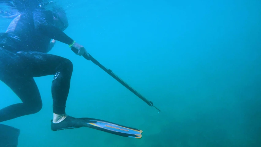 the man is diving underwater with his snorak