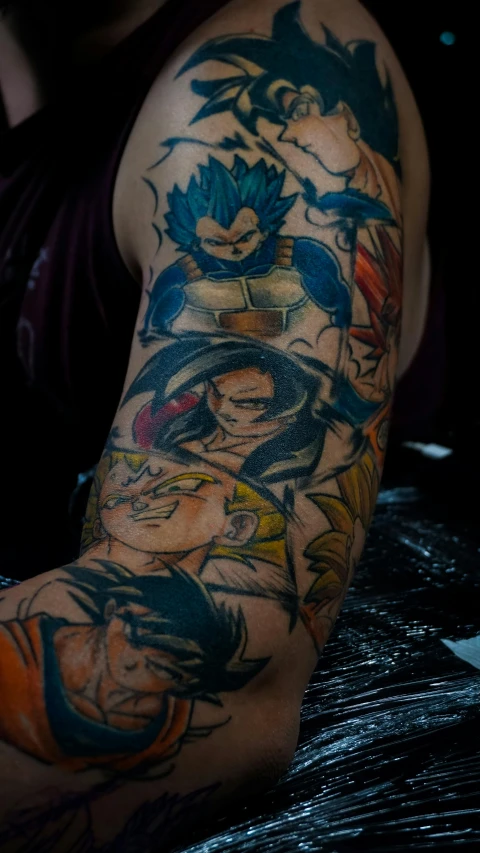 a sleeve of tattoos of dragon, and young gohan