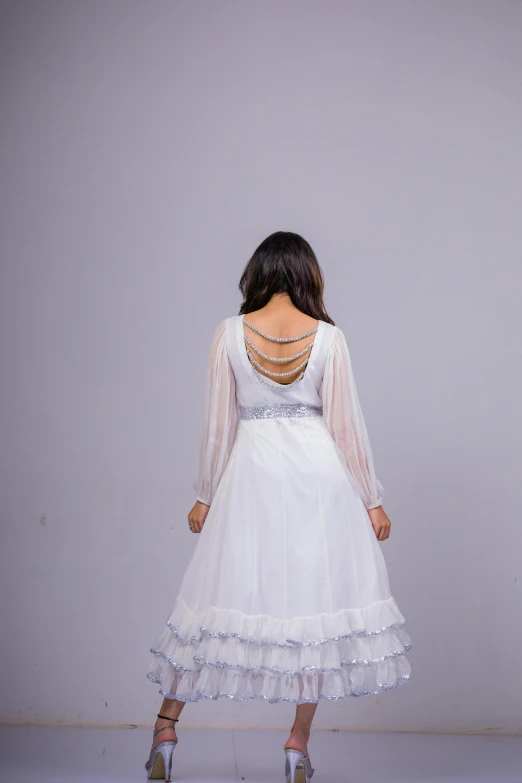 a woman in white dress with her back to the camera