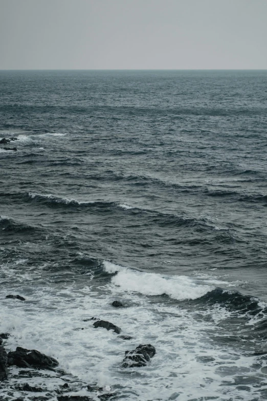 the surfer is walking towards his board in the water