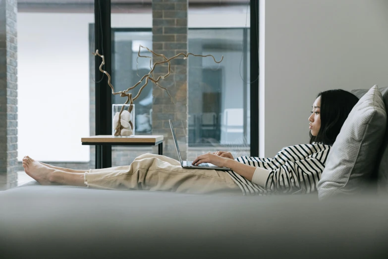 an image of a woman sitting on the couch working on her laptop