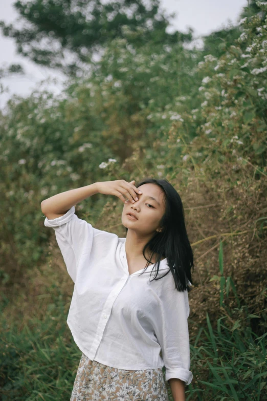 a woman posing for a po in front of trees