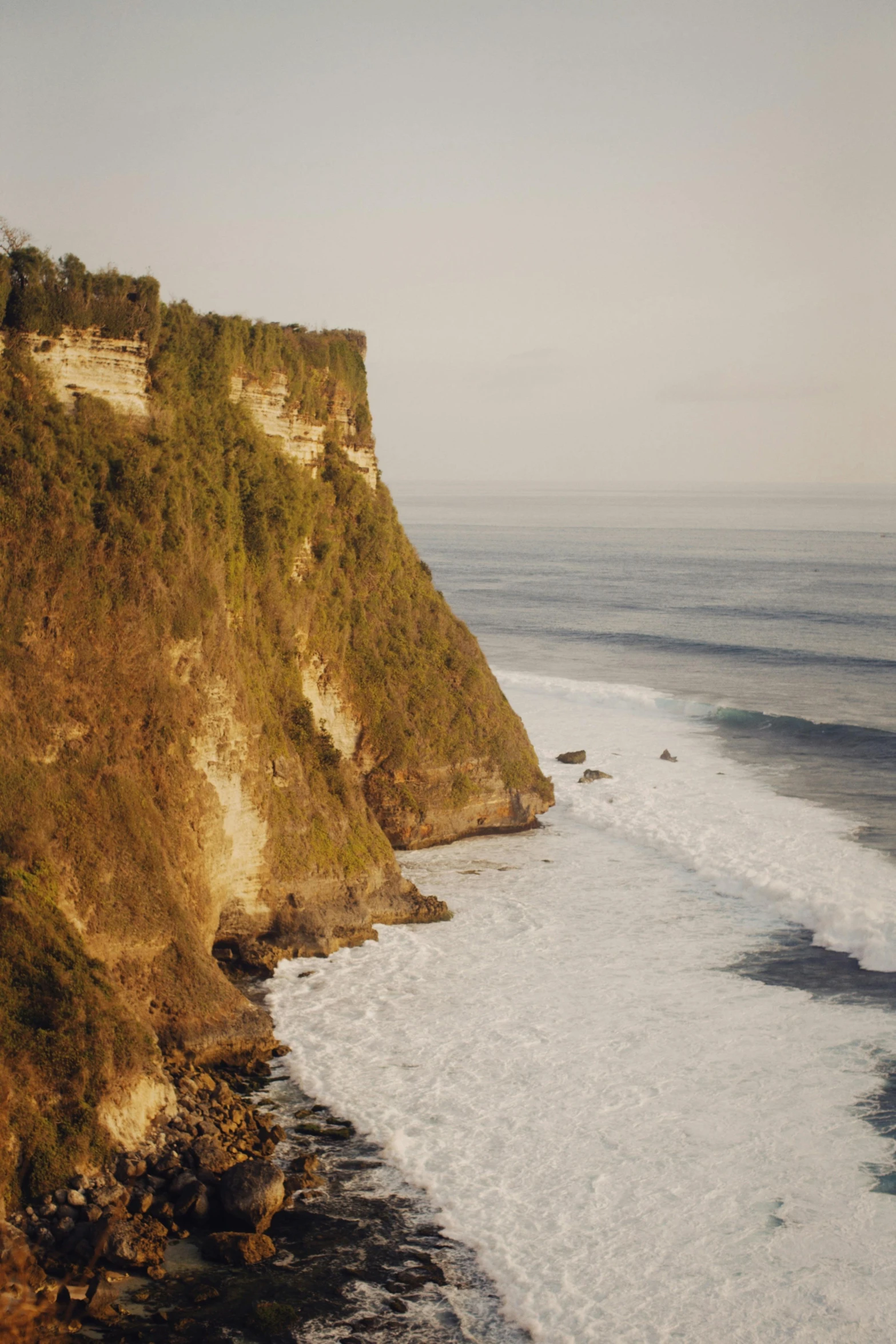 cliffs on the shore of the ocean with waves coming in