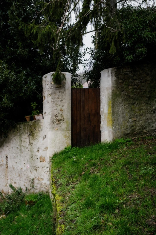 an old stone fence and doorway in a park