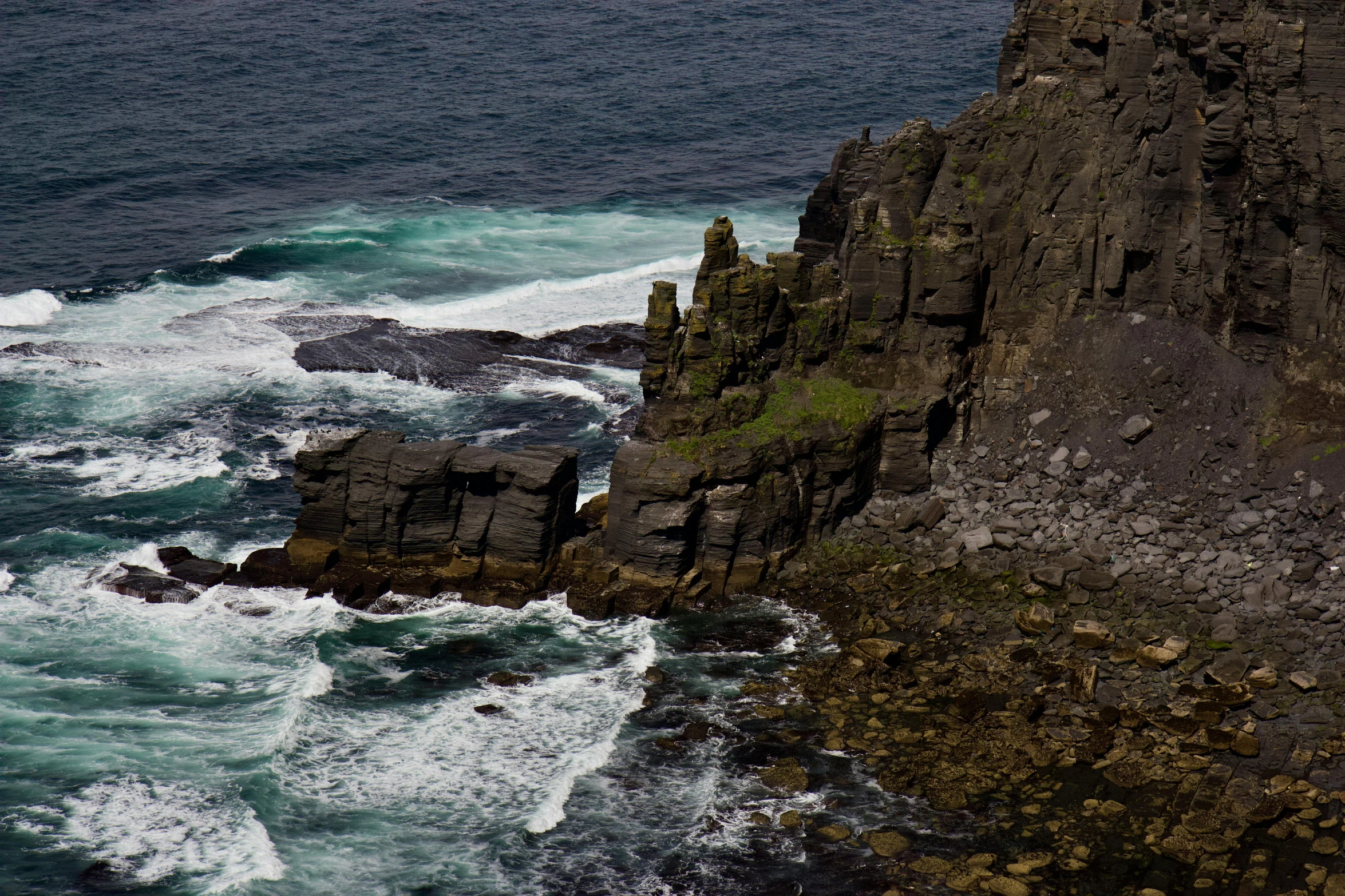 the large rock is standing on the cliff above the ocean